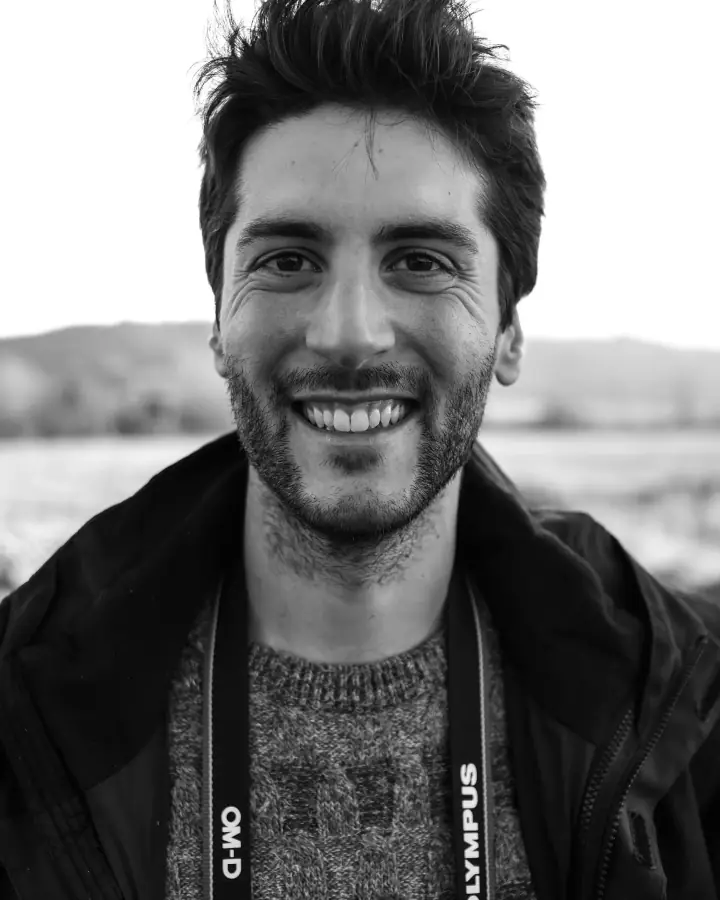Marco Nardini sorride, all'aperto, con la macchina fotografica al collo